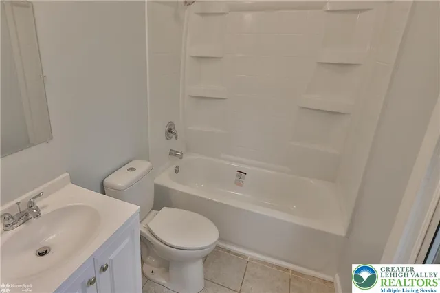 a white bath tub sitting next to a white sink and a toilet
