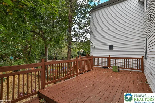 a view of a house with wooden deck front of house