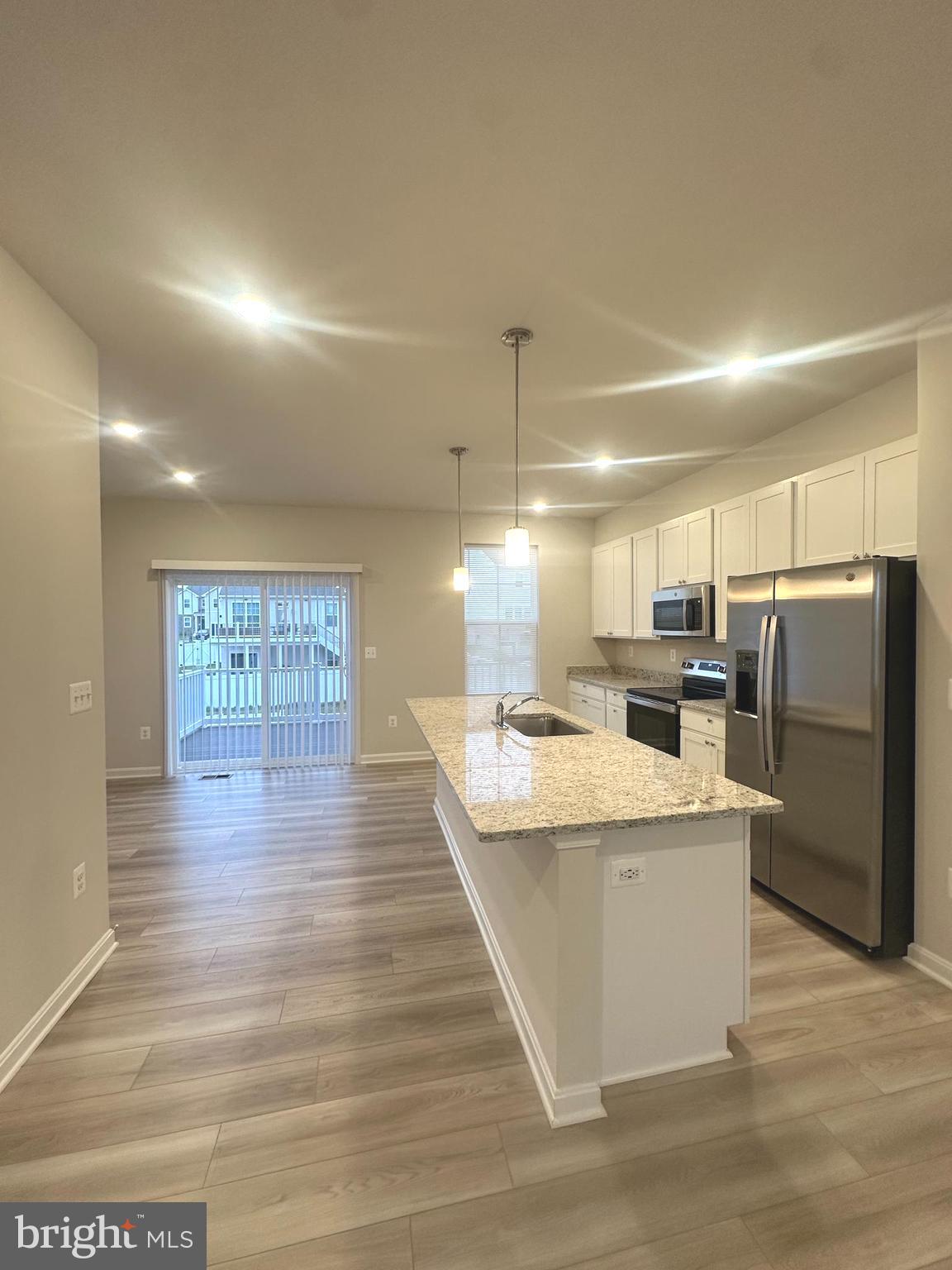 106 Telluride Way Charles Town, WV 25414 - Photo 13 of 55 a large kitchen with kitchen island a stove a refrigerator a sink dishwasher with a dining table and chairs with wooden floor