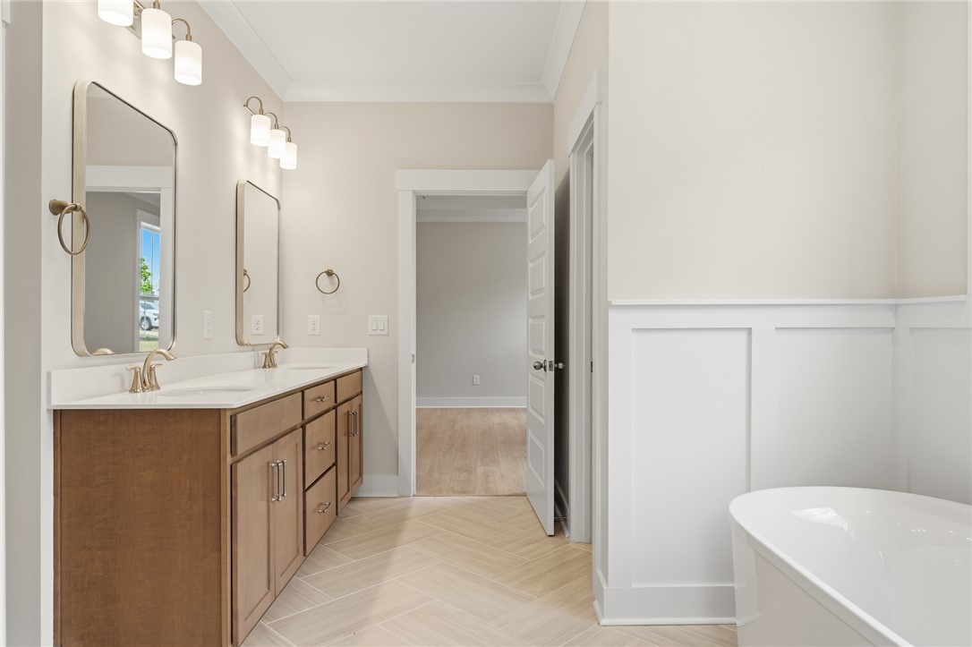 203 Timothy Court Anderson, SC 29621 - Photo 37 of 40 Herringbone-patterned floors lead to a sleek double vanity, offering a well-appointed bathroom retreat.