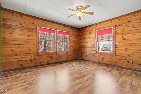 a view of empty room with a fan and a window