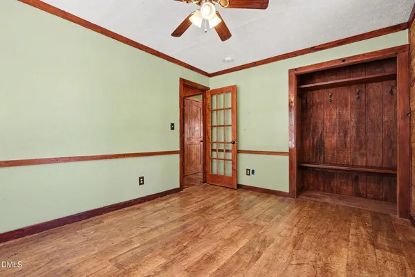 a bedroom with a bed a mirror on dresser and a chandelier