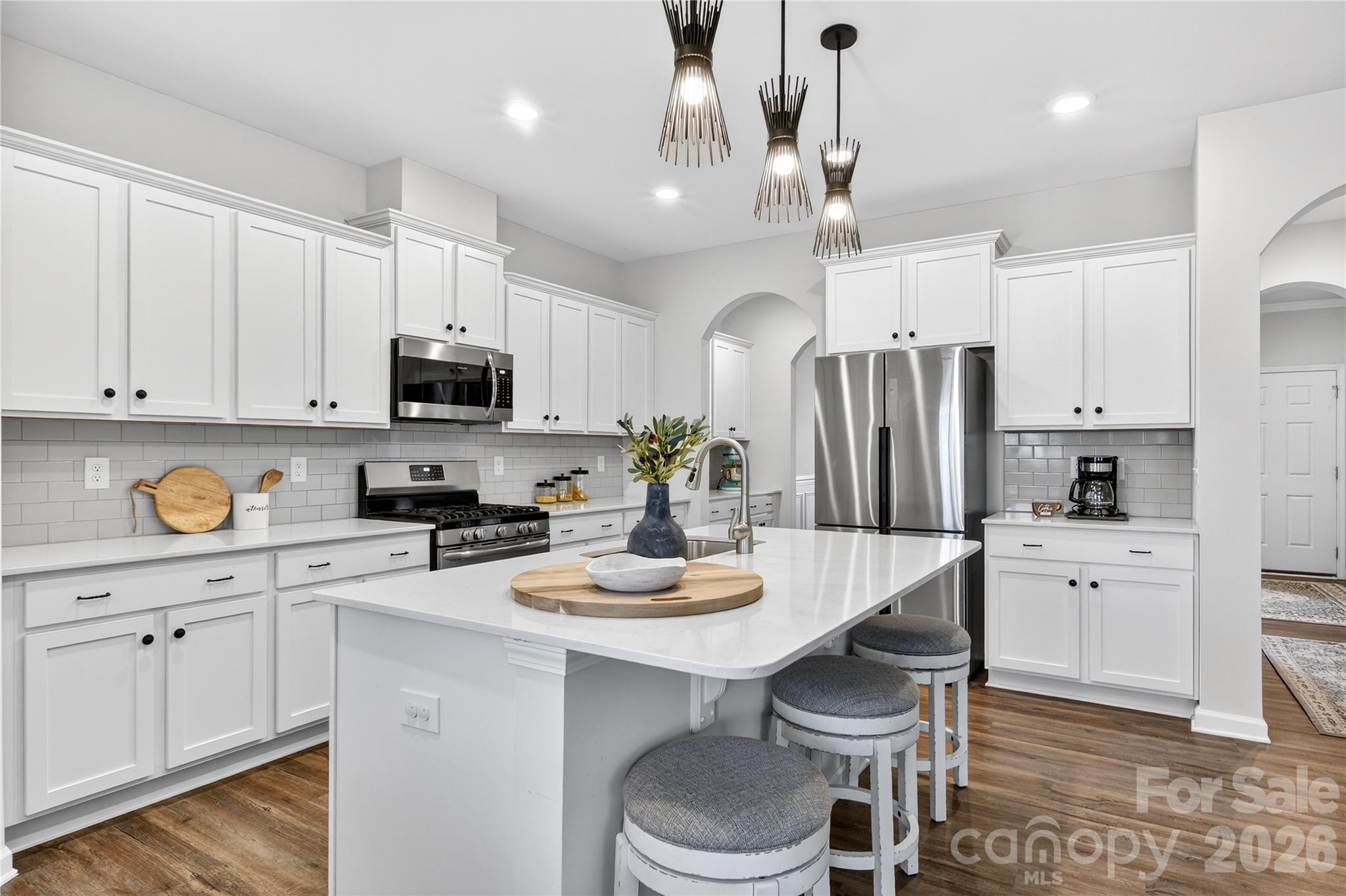 151 Outrigger Lane Troutman, NC 28166 - Photo 16 of 39 a kitchen with white cabinets stainless steel appliances and wooden floor