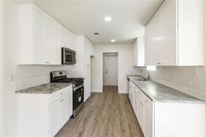 4715 Broken Elm Drive Spring, TX 77388 - Photo 17 of 35 a kitchen with granite countertop a sink a counter top space stainless steel appliances and cabinets