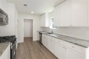 a kitchen with granite countertop white cabinets and white appliances