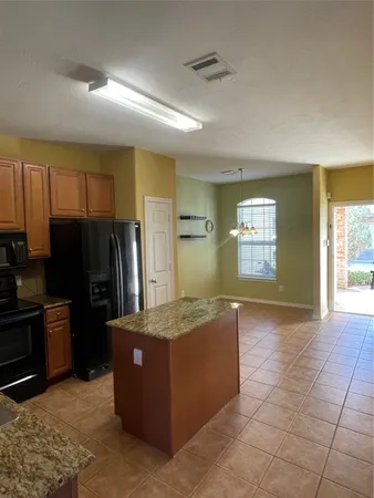 a kitchen with granite countertop a refrigerator and a sink
