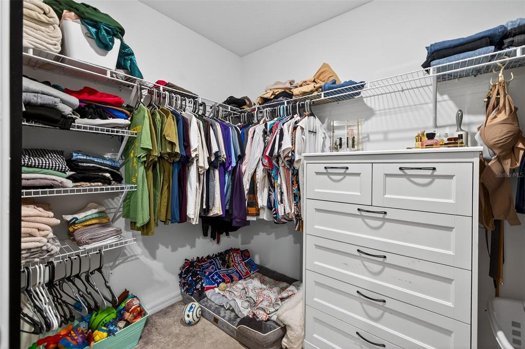 9324 Lemon Drop Loop Sun City Center, FL 33573 - Photo 16 of 32 a view of walk in closet with clothes and shoes