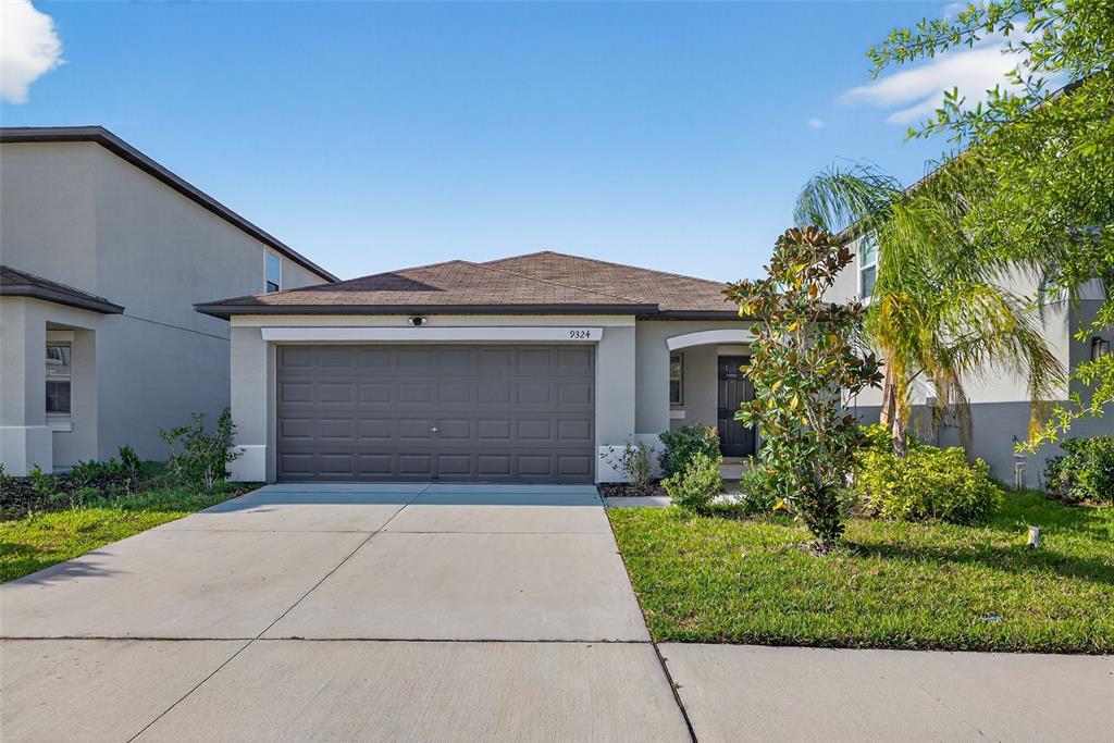 9324 Lemon Drop Loop Sun City Center, FL 33573 - Photo 31 of 32 front view of a house with a garden