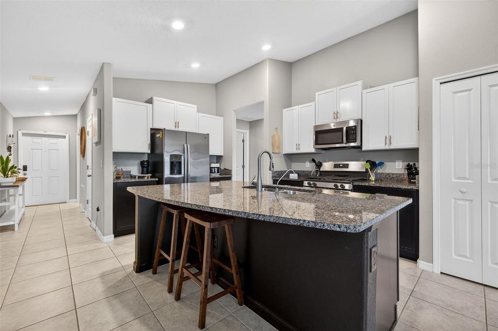 9324 Lemon Drop Loop Sun City Center, FL 33573 - Photo 6 of 32 a kitchen with stainless steel appliances granite countertop a stove top oven a sink dishwasher and a refrigerator