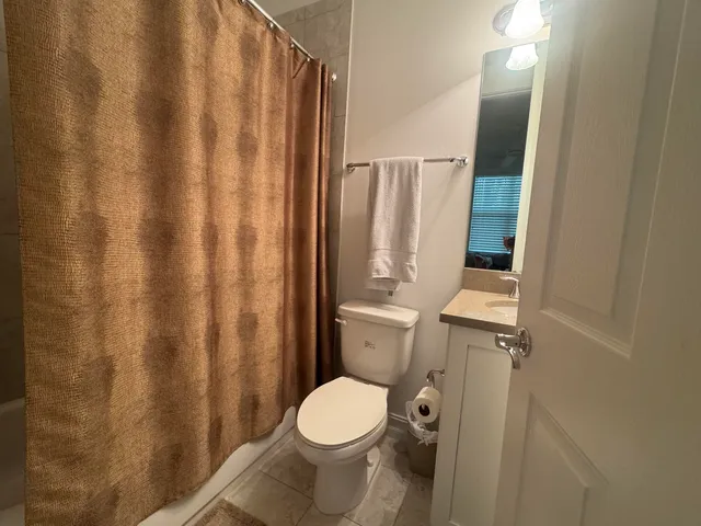 a white toilet sitting next to a shower curtain