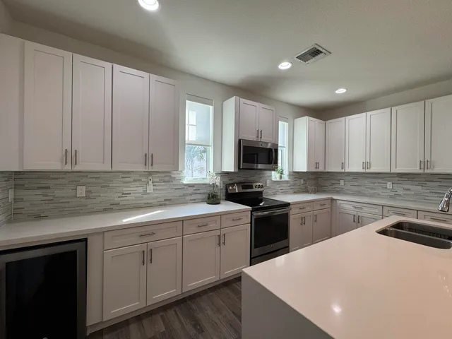 a kitchen with a sink stainless steel appliances and white cabinets