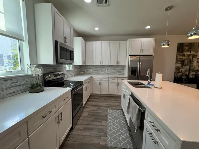 a kitchen with a sink a stove top oven and refrigerator
