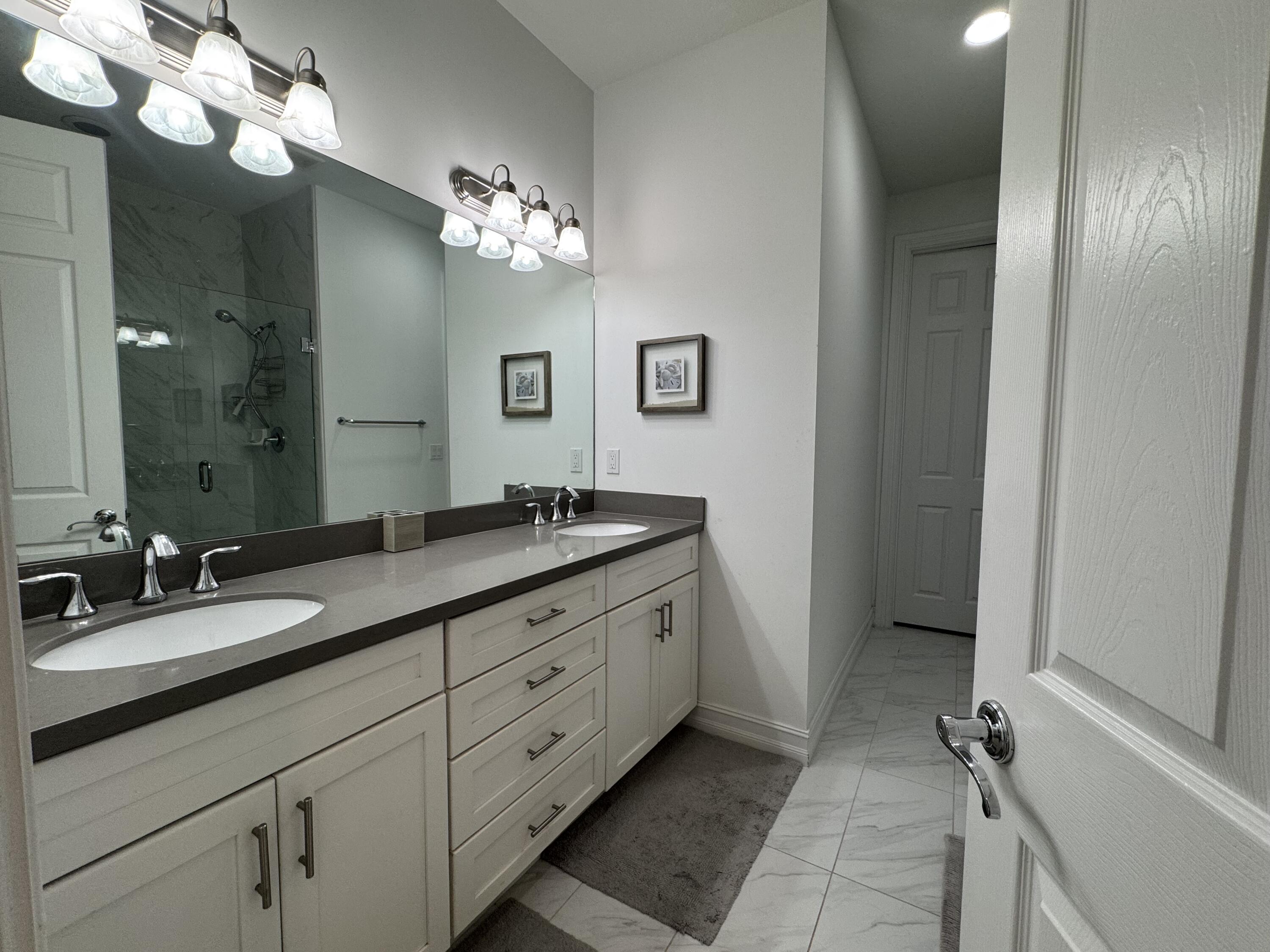 101 East Coda Circle, Unit C Delray Beach, FL 33444 - Photo 10 of 13 a bathroom with a double vanity sink and a mirror