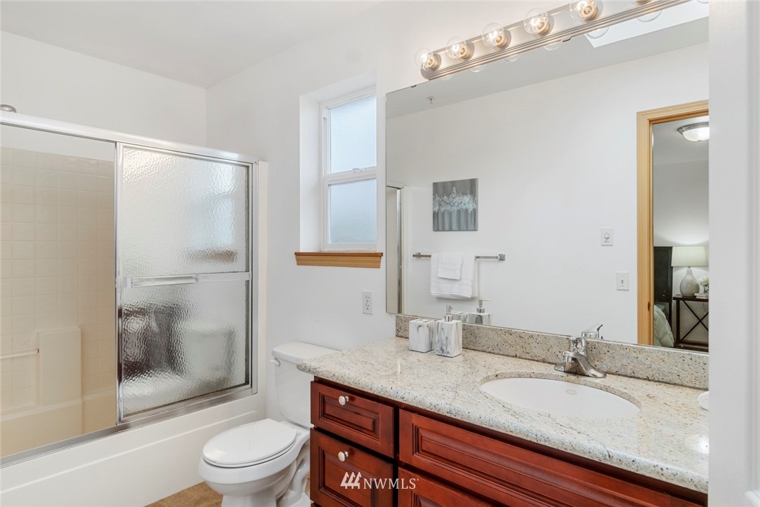 6018 Cady Road Everett, WA 98203 - Photo 13 of 16 a bathroom with a granite countertop sink toilet a mirror and shower