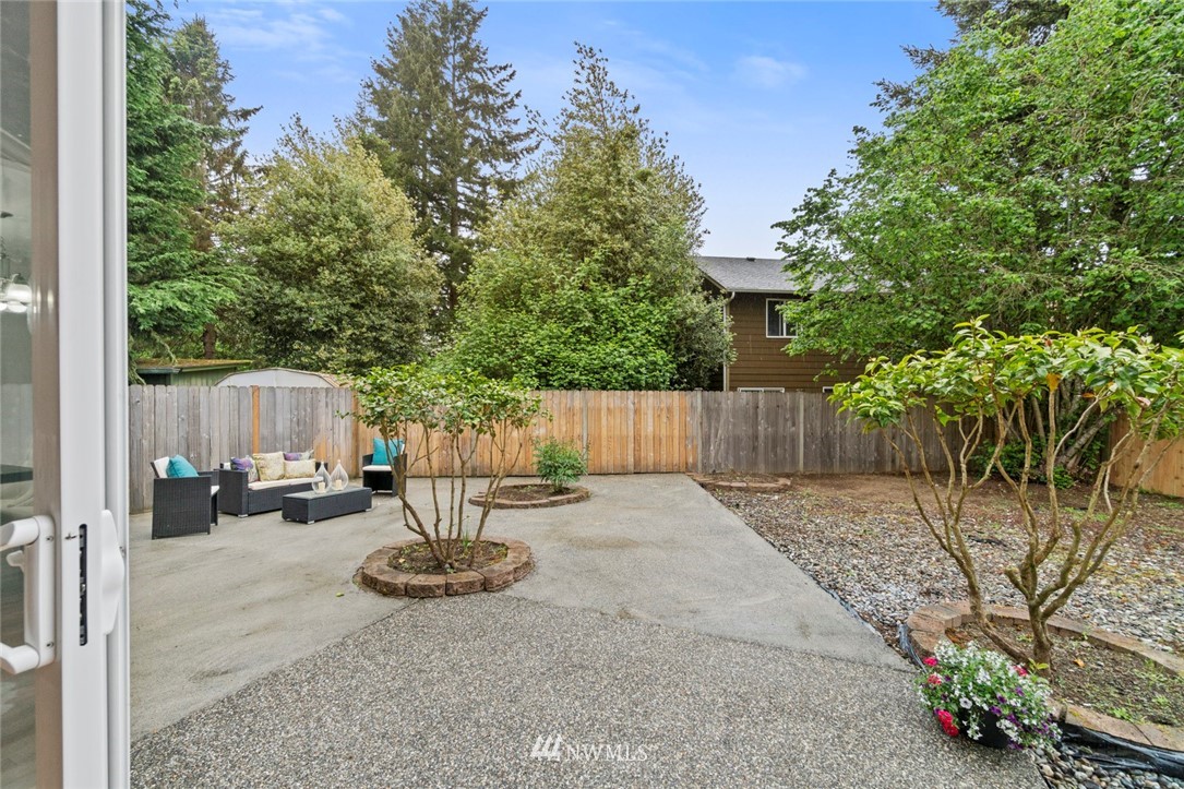 6018 Cady Road Everett, WA 98203 - Photo 16 of 16 a backyard of a house with table and chairs and wooden fence