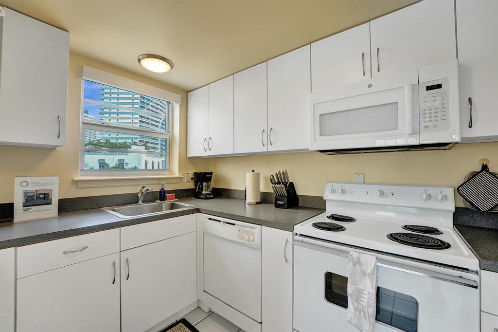 341 North Birch Road, Unit 416 Fort Lauderdale, FL 33304 - Photo 15 of 49 a kitchen with granite countertop a sink a stove a microwave and cabinets