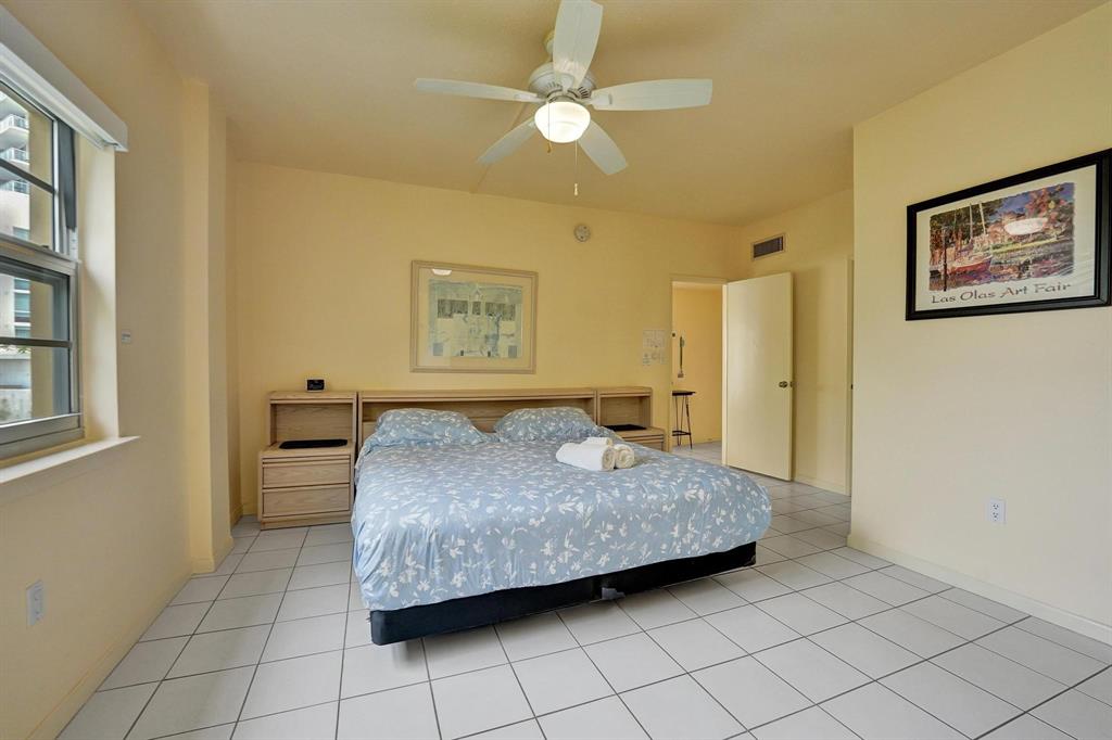 341 North Birch Road, Unit 416 Fort Lauderdale, FL 33304 - Photo 42 of 49 a bedroom with a bed and a chandelier