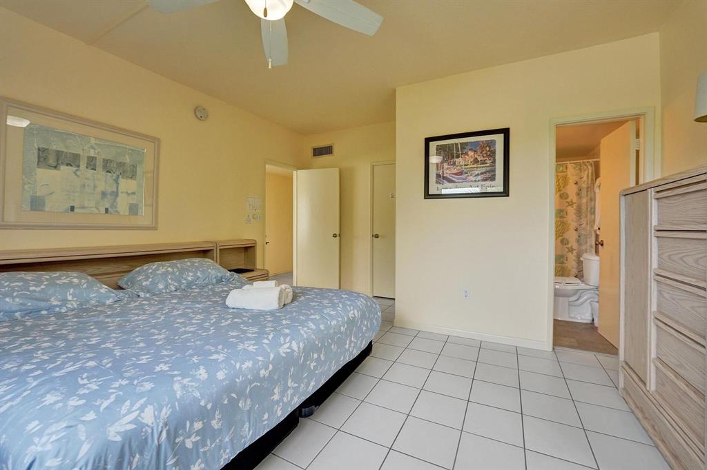 341 North Birch Road, Unit 416 Fort Lauderdale, FL 33304 - Photo 43 of 49 a spacious bedroom with a bed and a chandelier