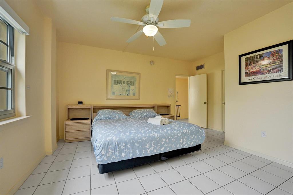 341 North Birch Road, Unit 416 Fort Lauderdale, FL 33304 - Photo 49 of 49 a bedroom with a bed and a chandelier