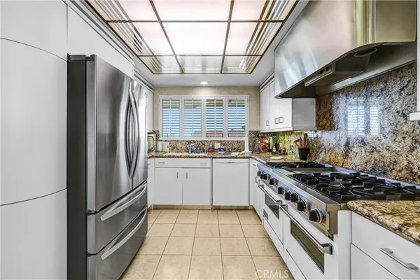 a kitchen with stainless steel appliances granite countertop a stove a refrigerator and a sink