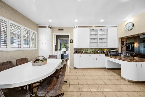 a large kitchen with granite countertop a stove a sink a dining table and chairs