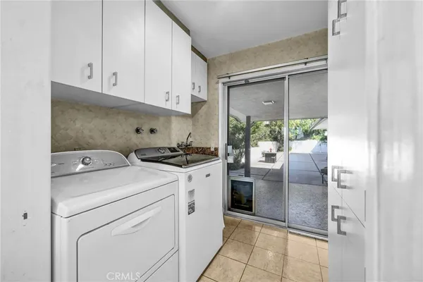 a kitchen with a refrigerator and white cabinets