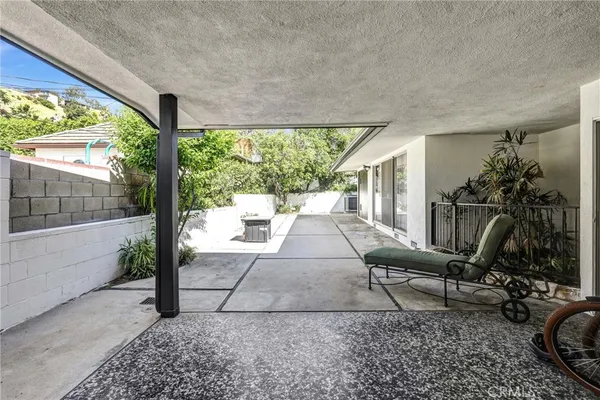 a view of a patio with couple of chairs and a fountain