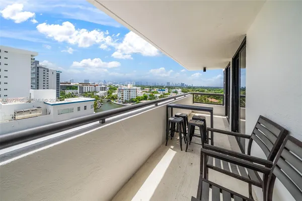 a view of a city from a balcony with furniture