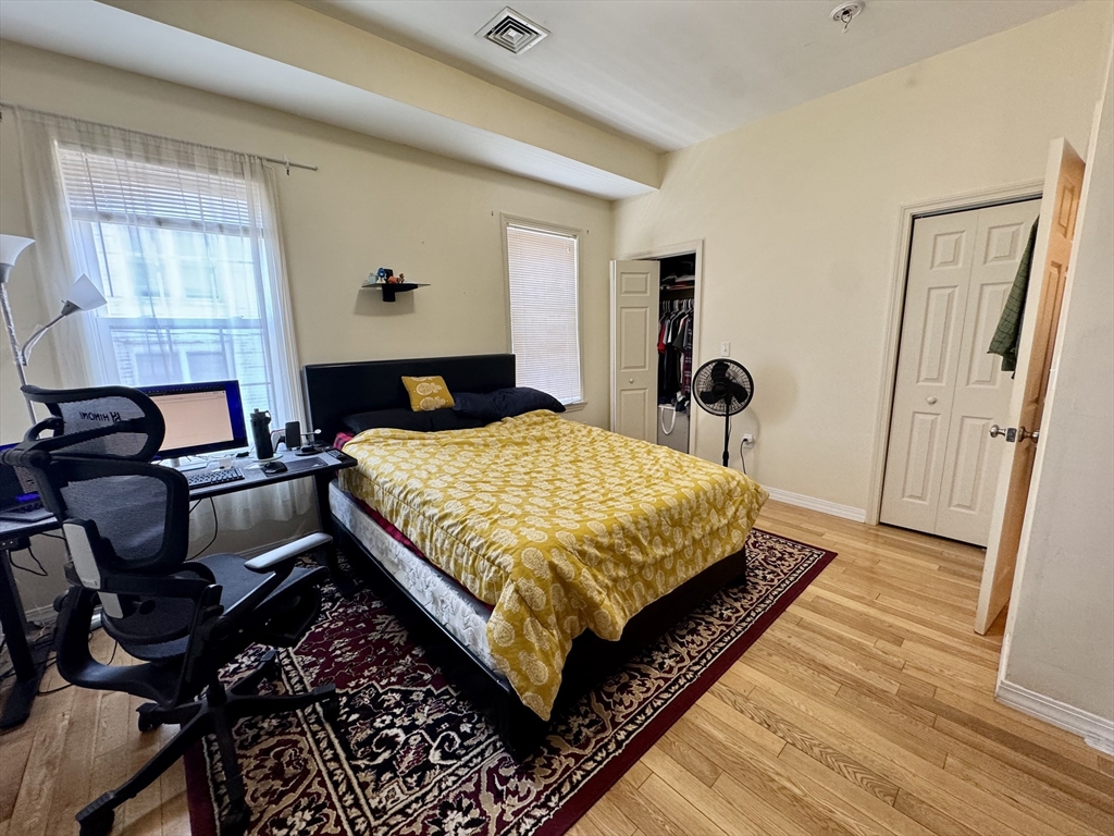 22 Elmore Street, Unit 2 Boston, MA 02119 - Photo 13 of 17 a bed sitting in a bedroom next to a window