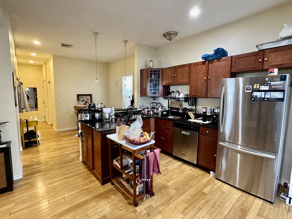 22 Elmore Street, Unit 2 Boston, MA 02119 - Photo 3 of 17 a kitchen with stainless steel appliances wooden floor and refrigerator