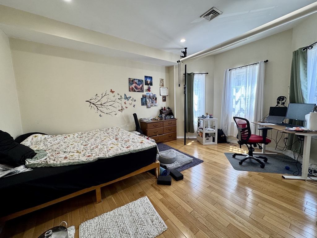 22 Elmore Street, Unit 2 Boston, MA 02119 - Photo 8 of 17 a bedroom with furniture and wooden floor