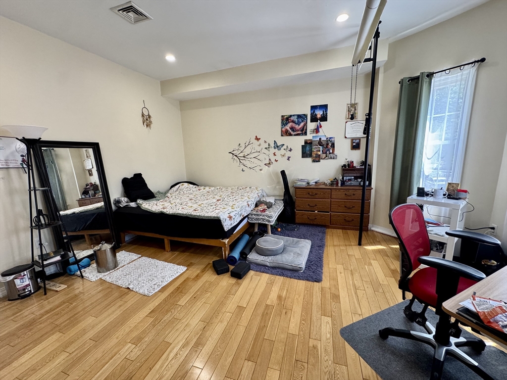 22 Elmore Street, Unit 2 Boston, MA 02119 - Photo 9 of 17 a bedroom with furniture and a wooden floor