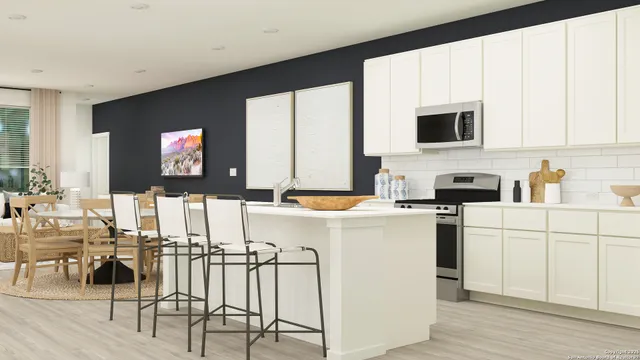 a kitchen with appliances cabinets and a chair