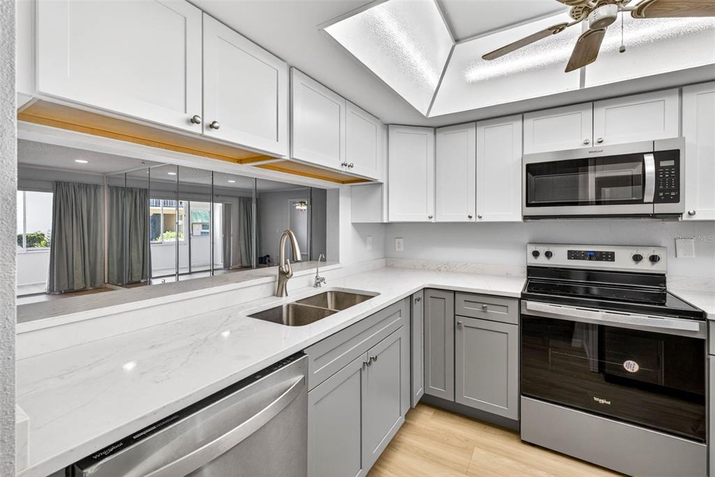 5197 Silent Loop, Unit 124 New Port Richey, FL 34652 - Photo 8 of 55 a kitchen with stainless steel appliances granite countertop a sink and a stove
