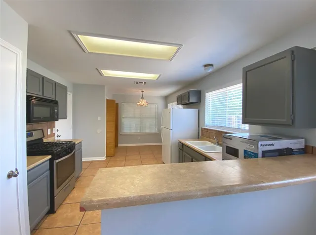 a kitchen with stainless steel appliances granite countertop a sink and a stove top oven