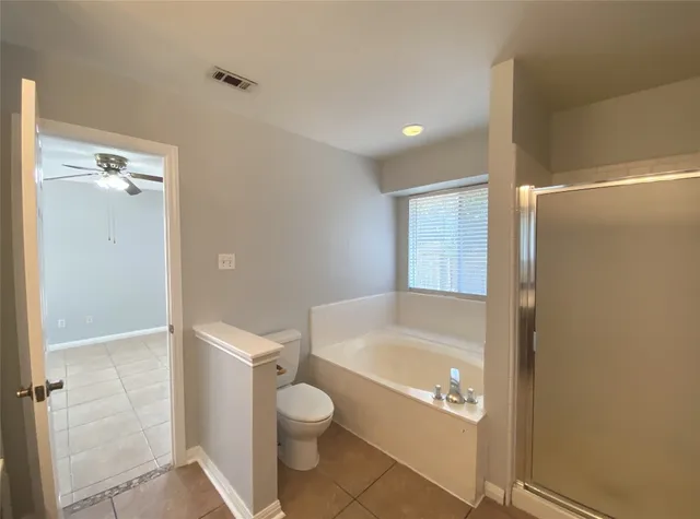 a bathroom with a granite countertop bathtub shower and toilet