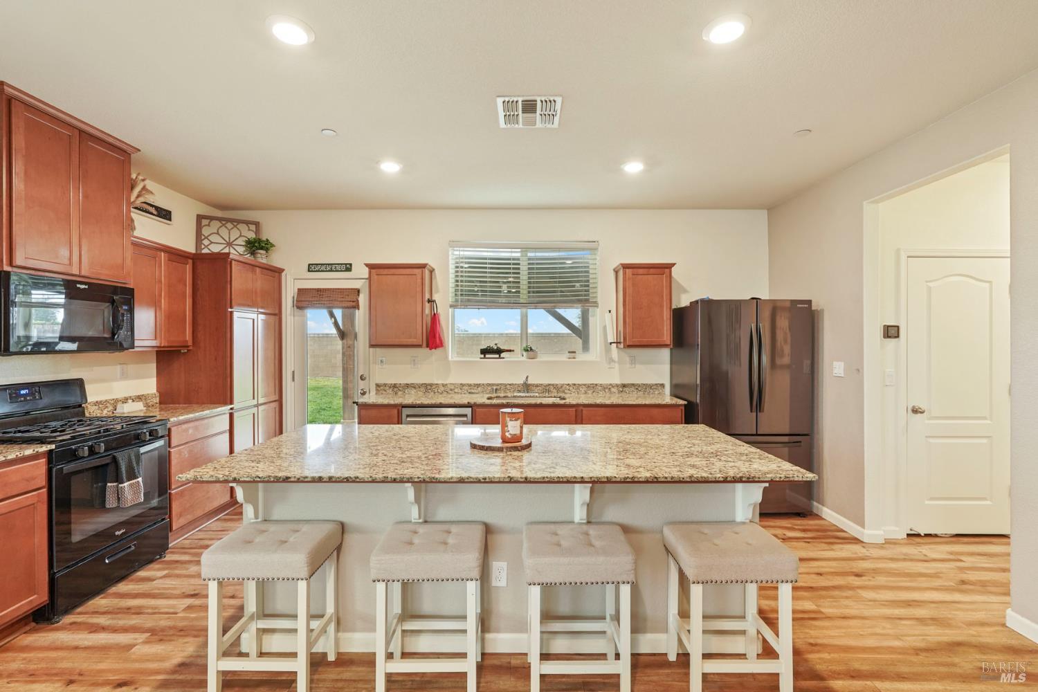 4725 Market Pl Square Rio Vista, CA 94571 - Photo 8 of 37 a kitchen with stainless steel appliances granite countertop a stove top oven a refrigerator and kitchen island