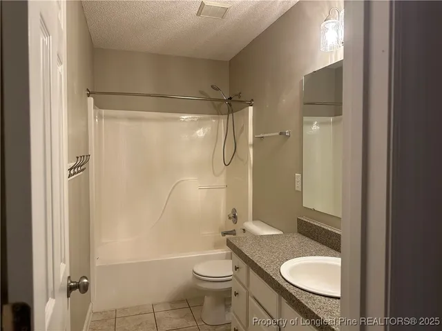 a bathroom with a granite countertop toilet sink and shower