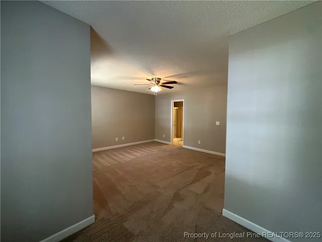 a view of a livingroom with a chandelier fan and a window