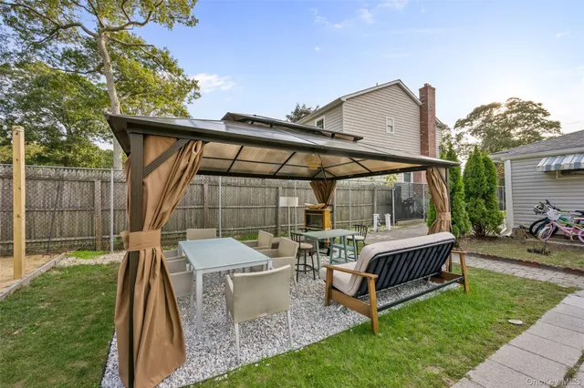 a backyard of a house with table and chairs
