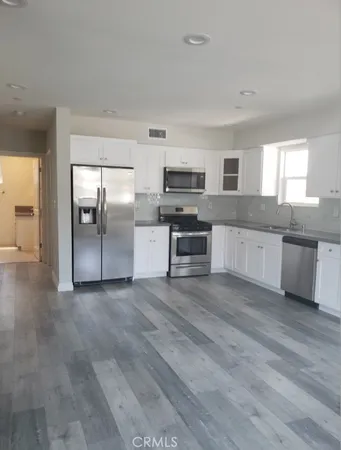 a large kitchen with cabinets and stainless steel appliances