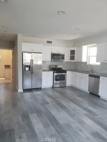a large kitchen with cabinets and stainless steel appliances