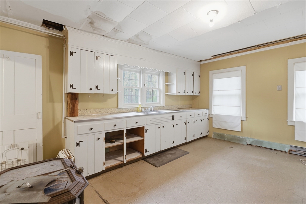 5 Gap Mountain Road Fitzwilliam, NH 03447 - Photo 5 of 31 a kitchen with white cabinets and wooden floors