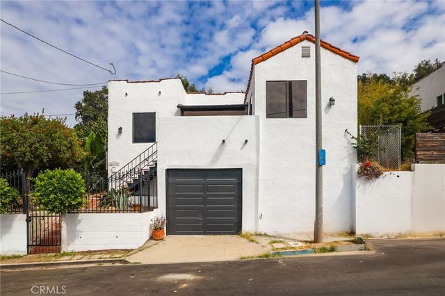 a view of a swimming pool with a patio and wooden fence