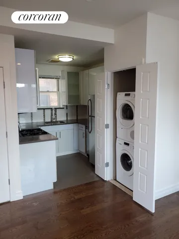 a kitchen with stainless steel appliances granite countertop a refrigerator a sink and a stove with wooden floor