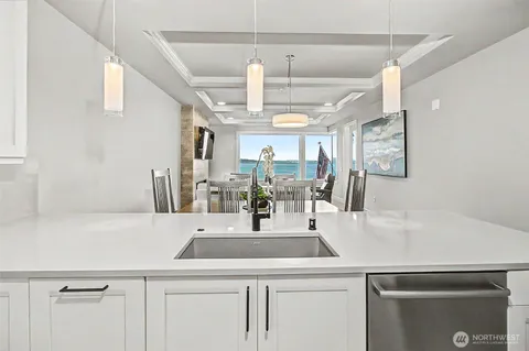 a view of a kitchen with a sink and dishwasher with wooden floor
