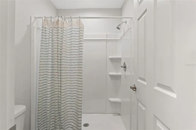 a bathroom with a shower curtain and a toilet
