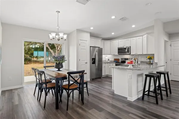 a kitchen with stainless steel appliances granite countertop a dining table chairs and granite counter tops