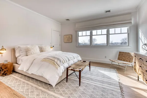 a bedroom with a bed and a large window