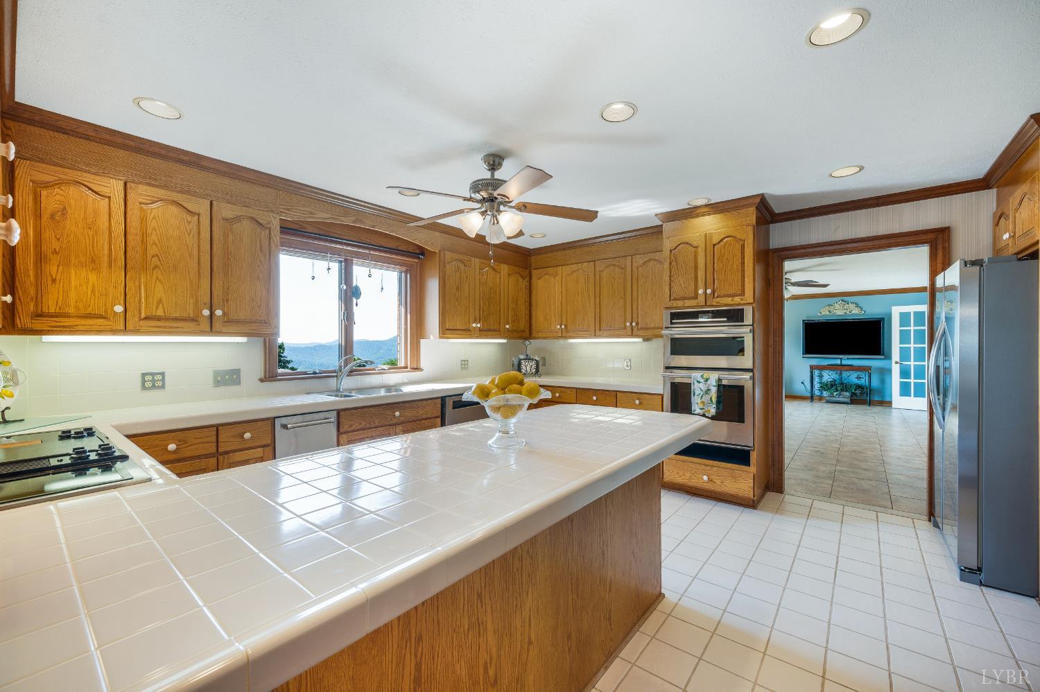 355 Dyson Road Amherst, VA 24521 - Photo 17 of 96 a large kitchen with kitchen island a large counter space a sink appliances and a window